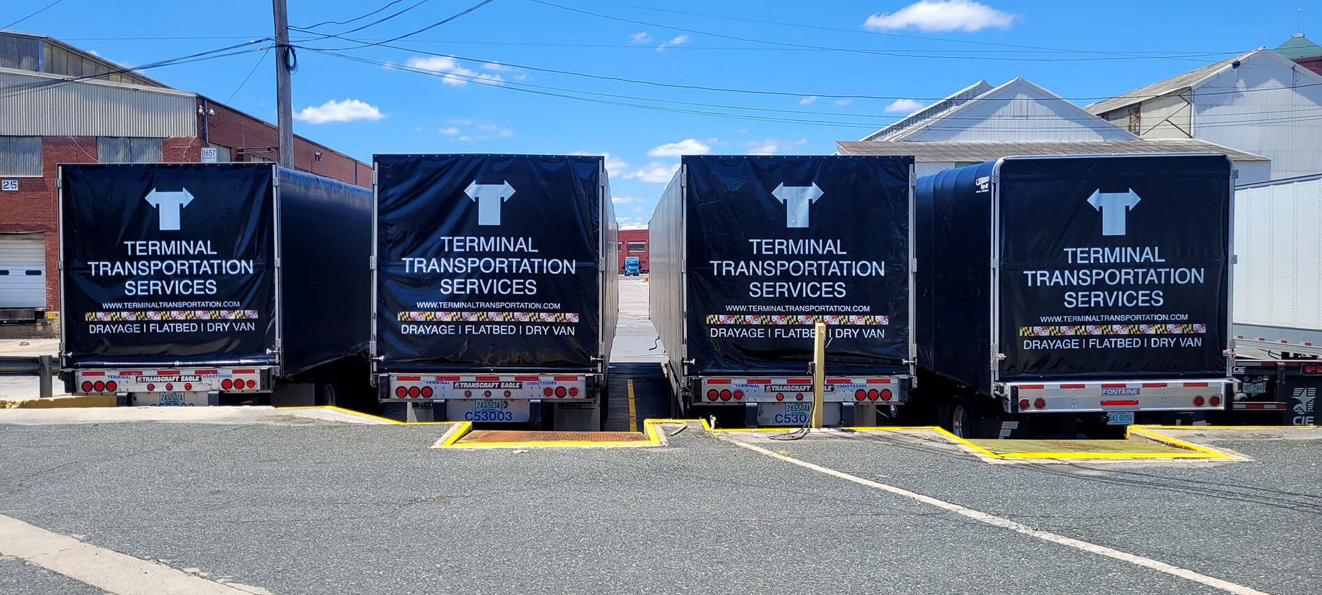 conestoga flatbed parked in front of terminal transportation services office building