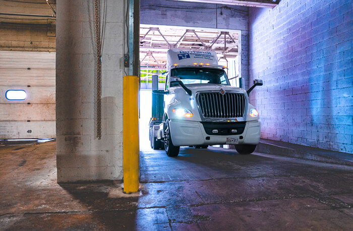 flatbed truck driving into a warehouse