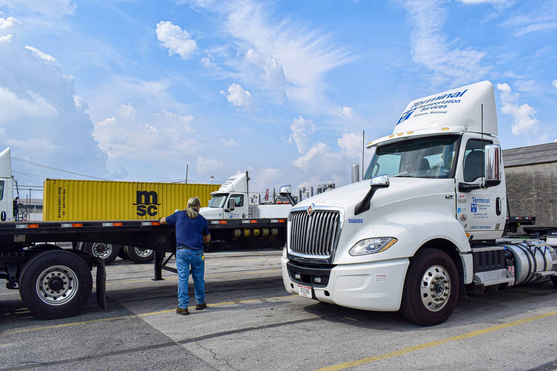 truck driver lowering flatbed trailer